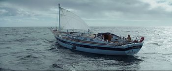 Movie still from “Adrift” (2018), directed by Baltasar Kormákur – A sailboat in the middle of the ocean under a cloudy sky; Extreme Wide shot, High angle