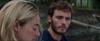 Movie still from “Adrift” (2018), directed by Baltasar Kormákur – A man and a woman sitting next to each other in front of trees; Close Up shot, Over the shoulder angle