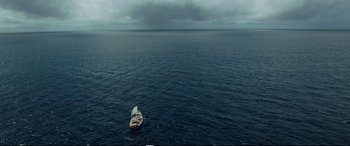 Movie still from “Adrift” (2018), directed by Baltasar Kormákur – A boat floating on top of a body of water; Extreme Wide shot, Overhead angle