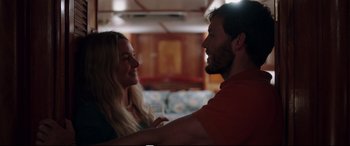 Movie still from “Adrift” (2018), directed by Baltasar Kormákur – A man and a woman holding a wine glass in a room; Medium shot, Over the shoulder angle