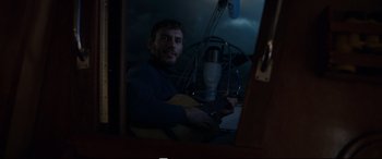 Movie still from “Adrift” (2018), directed by Baltasar Kormákur – A man sitting in front of a microphone holding a guitar; Medium shot, Over the shoulder angle