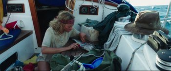 Movie still from “Adrift” (2018), directed by Baltasar Kormákur – A man sitting on top of a wooden boat; Medium shot, High angle