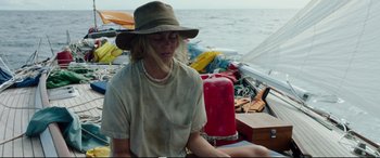 Movie still from “Adrift” (2018), directed by Baltasar Kormákur – A woman sitting on the back of a boat in the water; Medium shot, High angle