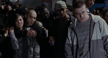 Movie still from “Adulthood” (2008), directed by Noel Clarke – A group of young men standing next to each other in a room; Medium shot, High angle