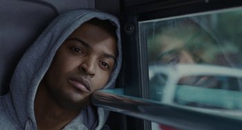 Movie still from “Adulthood” (2008), directed by Noel Clarke – A man in a hooded sweatshirt looking out of a window; Close Up shot, Low angle