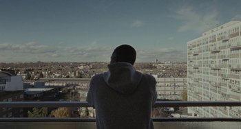 Movie still from “Adulthood” (2008), directed by Noel Clarke – A man looking out over a city from a balcony; Wide shot, High angle