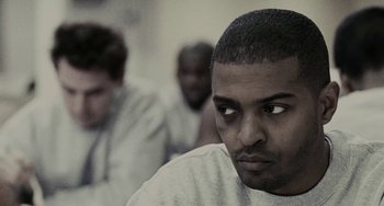 Movie still from “Adulthood” (2008), directed by Noel Clarke – A black man with a beard is looking at the camera; Close Up shot, Over the shoulder angle