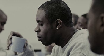 Movie still from “Adulthood” (2008), directed by Noel Clarke – A person sitting down with his eyes closed; Close Up shot, Low angle
