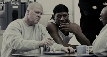 Movie still from “Adulthood” (2008), directed by Noel Clarke – Two men sitting at a table with a plate of food; Close Up shot, Over the shoulder angle