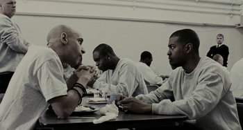 Movie still from “Adulthood” (2008), directed by Noel Clarke – A group of men sitting at a table in a room; Medium shot, High angle