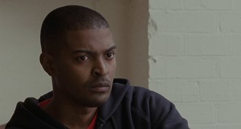 Movie still from “Adulthood” (2008), directed by Noel Clarke – A person wearing a hooded sweatshirt; Close Up shot, Over the shoulder angle
