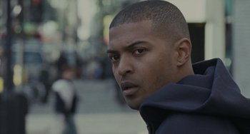 Movie still from “Adulthood” (2008), directed by Noel Clarke – A person wearing a hoodie; Close Up shot, Over the shoulder angle