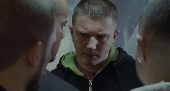 Movie still from “Adulthood” (2008), directed by Noel Clarke – A man in a black jacket is looking at another man in a green jacket; Close Up shot, Over the shoulder angle