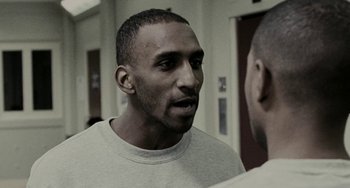 Movie still from “Adulthood” (2008), directed by Noel Clarke – A man in a white shirt talking to another man in a white shirt; Close Up shot, Over the shoulder angle