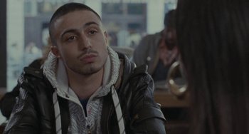 Movie still from “Adulthood” (2008), directed by Noel Clarke – A man sitting in front of another man in a room; Close Up shot, Over the shoulder angle