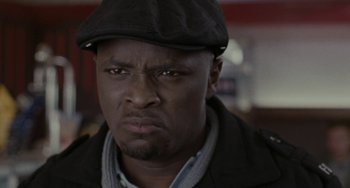 Movie still from “Adulthood” (2008), directed by Noel Clarke – A person wearing a hat and a jacket; Close Up shot, Low angle