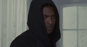 Movie still from “Adulthood” (2008), directed by Noel Clarke – A man in a black hooded sweatshirt stares at the camera; Close Up shot, Low angle