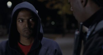 Movie still from “Adulthood” (2008), directed by Noel Clarke – A man wearing a hooded sweatshirt talking to another man; Close Up shot, Over the shoulder angle