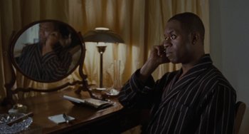 Movie still from “Adulthood” (2008), directed by Noel Clarke – A man sitting in front of a mirror talking on a cell phone; Medium shot, High angle