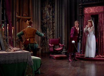 Movie still from “Adventures of Don Juan” (1948), directed by Vincent Sherman – A man and a woman are standing in front of a mirror; Wide shot, High angle