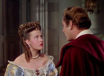 Movie still from “Adventures of Don Juan” (1948), directed by Vincent Sherman – A man and a woman are talking to each other; Medium shot, Over the shoulder angle