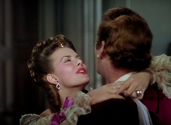 Movie still from “Adventures of Don Juan” (1948), directed by Vincent Sherman – A man and a woman in formal wear embracing each other; Close Up shot, Over the shoulder angle