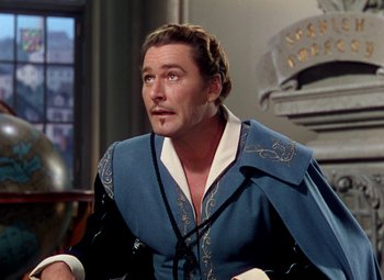 Movie still from “Adventures of Don Juan” (1948), directed by Vincent Sherman – A person sitting down wearing a suit; Medium shot, Over the shoulder angle