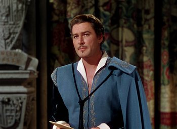 Movie still from “Adventures of Don Juan” (1948), directed by Vincent Sherman – A man wearing a blue robe and holding a sword; Medium shot, Over the shoulder angle