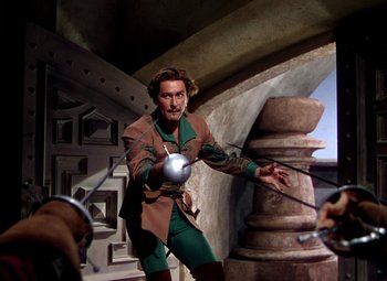 Movie still from “Adventures of Don Juan” (1948), directed by Vincent Sherman – A man dressed as robin hood is holding a sword; Medium shot, High angle