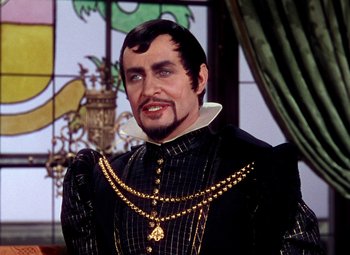 Movie still from “Adventures of Don Juan” (1948), directed by Vincent Sherman – A person wearing a suit and a necklace; Medium shot, Over the shoulder angle