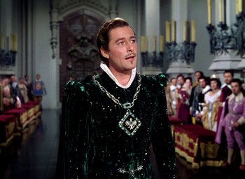 Movie still from “Adventures of Don Juan” (1948), directed by Vincent Sherman – A man in a green outfit standing next to a crowd of people; Medium shot, High angle