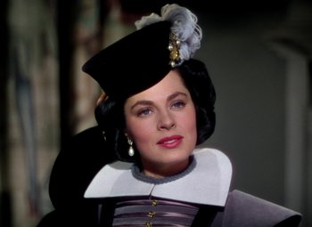 Movie still from “Adventures of Don Juan” (1948), directed by Vincent Sherman – A woman wearing a black hat and a black and white outfit; Close Up shot, Over the shoulder angle