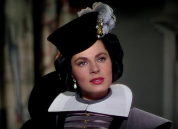 Movie still from “Adventures of Don Juan” (1948), directed by Vincent Sherman – A woman wearing a black hat and a black and white outfit; Close Up shot, Over the shoulder angle
