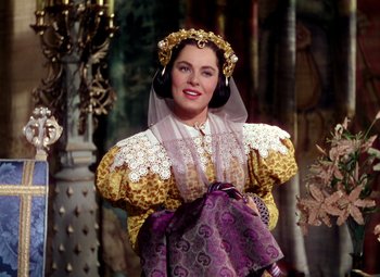 Movie still from “Adventures of Don Juan” (1948), directed by Vincent Sherman – A woman dressed as a medieval princess in a costume; Medium shot, Over the shoulder angle