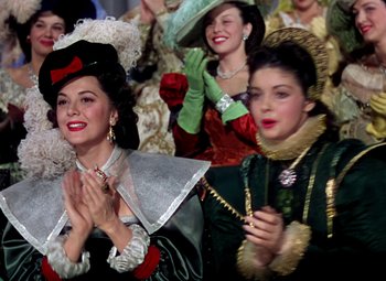 Movie still from “Adventures of Don Juan” (1948), directed by Vincent Sherman – A group of women dressed in period clothing; Medium shot, Low angle