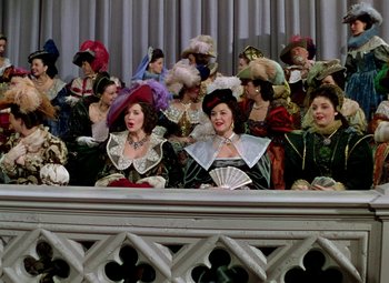 Movie still from “Adventures of Don Juan” (1948), directed by Vincent Sherman – A group of people dressed up in costumes; Medium shot, Low angle