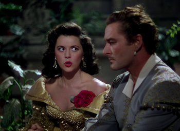 Movie still from “Adventures of Don Juan” (1948), directed by Vincent Sherman – A man and a woman are sitting next to each other; Close Up shot, Over the shoulder angle