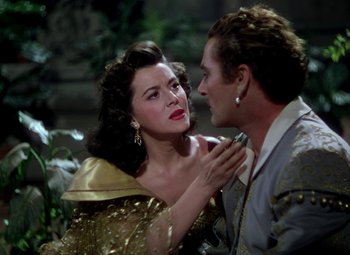 Movie still from “Adventures of Don Juan” (1948), directed by Vincent Sherman – A man and a woman are looking at one another; Close Up shot, Over the shoulder angle