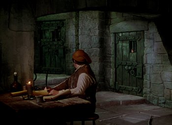Movie still from “Adventures of Don Juan” (1948), directed by Vincent Sherman – A man sitting at a table with a candle in front of him; Wide shot, High angle