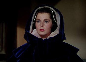 Movie still from “Adventures of Don Juan” (1948), directed by Vincent Sherman – A woman wearing a blue and white hooded cape; Close Up shot, Low angle