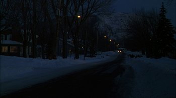 Movie still from “Affliction” (1997), directed by Paul Schrader – A street at night in the snow with lights on; Extreme Wide shot, Low angle