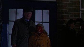Movie still from “Affliction” (1997), directed by Paul Schrader – A man and a woman standing next to each other in front of a brick building; Medium shot, Over the shoulder angle
