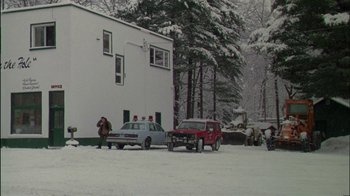 Movie still from “Affliction” (1997), directed by Paul Schrader – A group of people standing next to cars in the snow; Extreme Wide shot, Low angle