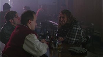Movie still from “Affliction” (1997), directed by Paul Schrader – Two men sitting at a table with bottles of beer; Medium shot, Over the shoulder angle