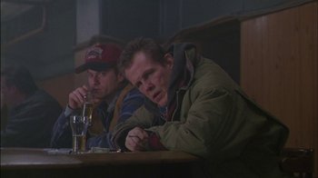 Movie still from “Affliction” (1997), directed by Paul Schrader – A couple of men sitting at a table with a drink; Medium shot, Low angle