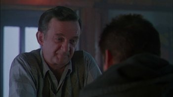 Movie still from “Affliction” (1997), directed by Paul Schrader – An older man looking at a younger man in front of a mirror; Close Up shot, Over the shoulder angle