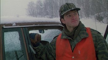 Movie still from “Affliction” (1997), directed by Paul Schrader – A man in a hunting vest driving in the snow; Medium shot, Over the shoulder angle