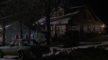 Movie still from “Affliction” (1997), directed by Paul Schrader – A person standing in front of a house at night; Extreme Wide shot, Low angle