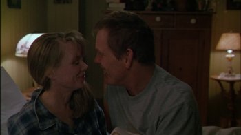 Movie still from “Affliction” (1997), directed by Paul Schrader – A man and a woman smiling at each other in a room; Close Up shot, Over the shoulder angle