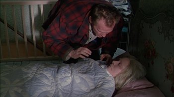 Movie still from “Affliction” (1997), directed by Paul Schrader – A man and a woman laying in a bed together; Medium shot, High angle
